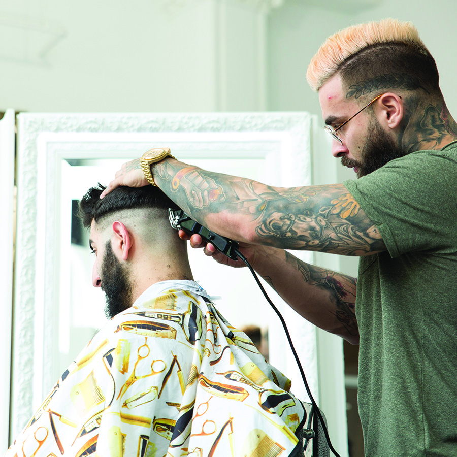 Barber trimming hair for male customer
