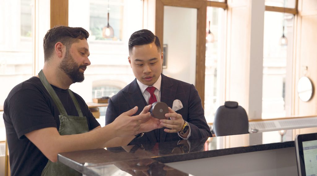 Barber showing client product in a modern store